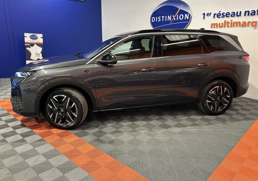 Vue latérale droite du Peugeot 5008 Hybrid gris titane, soulignant ses jantes noires et son design moderne.