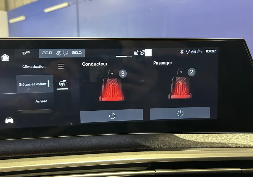 Écran tactile intérieur du Peugeot 5008 Hybrid 2025 montrant le réglage des sièges chauffants conducteur et passager.