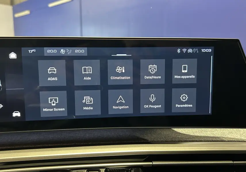 Écran tactile central du tableau de bord du Peugeot 5008 Hybrid gris titane, affichant le menu principal connecté.