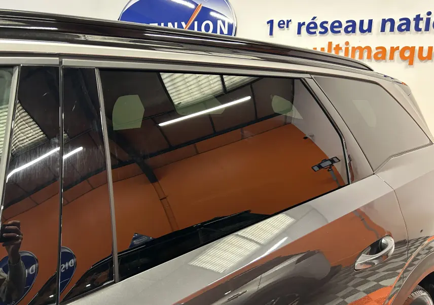 Vue latérale droite du Peugeot 5008 Hybrid gris titane, mettant en valeur les vitres teintées et la poignée de porte chrome.