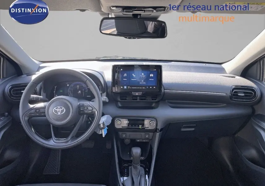 Vue frontale de l'habitacle de la Toyota Yaris Hybrid 116ch 2025, tableau de bord noir avec écran tactile central.
