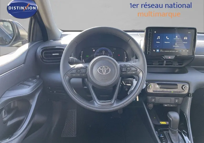 Intérieur de la Toyota Yaris Hybrid 116ch 2025, vue frontale du poste de conduite avec volant et écran tactile noir.