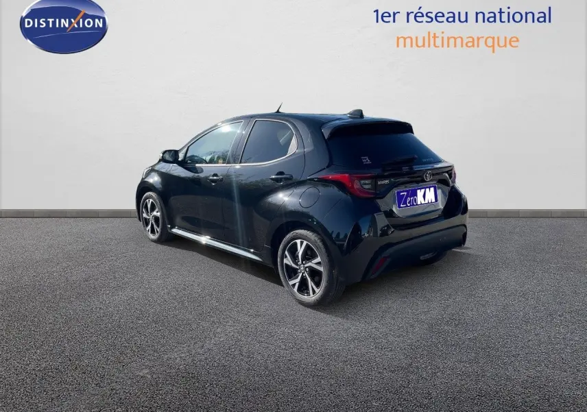 Toyota Yaris Hybrid noir métal vue 3/4 arrière côté gauche avec jantes bi-ton et feux LED distinctifs.