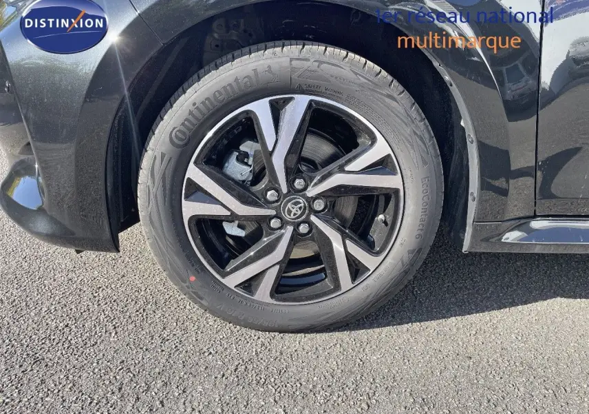 Gros plan sur la roue avant droite de la Toyota Yaris Hybrid 2025 noir métal avec jante alliage bicolore distinctive.