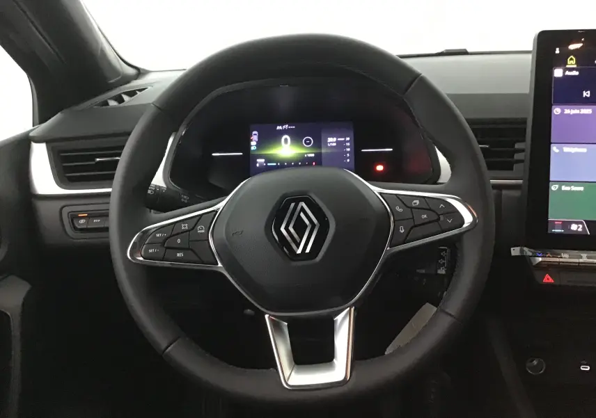 Vue frontale du volant noir du Renault Captur 2025 avec commandes intégrées et tableau de bord numérique éclairé.