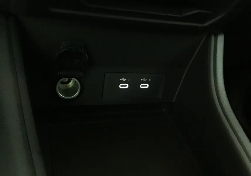 Prise allume-cigare et deux ports USB éclairés dans la console centrale du Renault Captur noir/gris perle 2025.