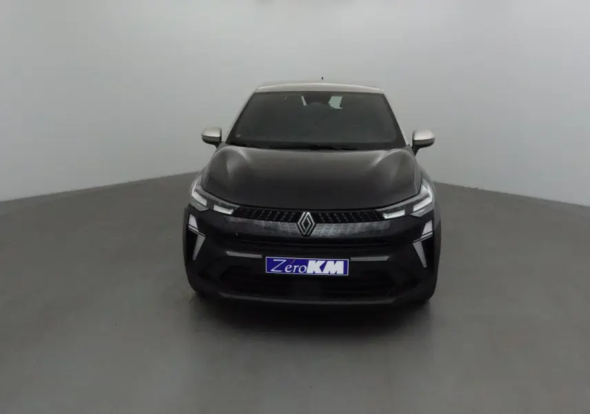 Vue frontale d'un Renault Captur 2025 noir et gris perle avec calandre moderne et phares LED allumés.
