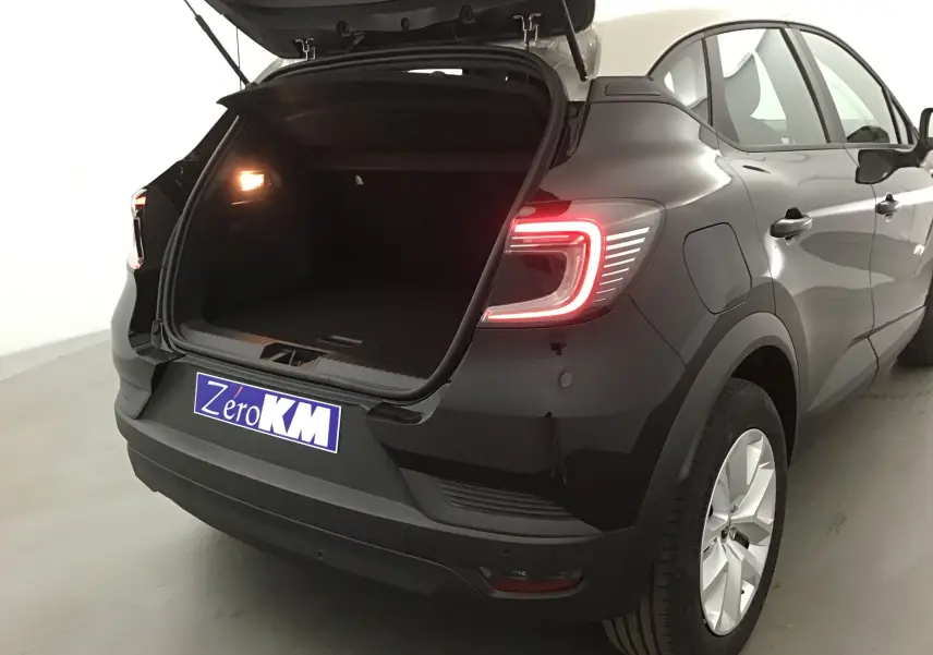 Vue 3/4 arrière droite du Renault Captur 2025 noir/gris perle avec coffre ouvert et feux arrière allumés