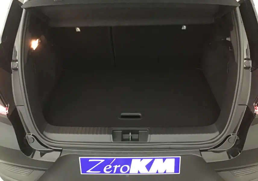 Coffre ouvert d'un Renault Captur 1.0 TCE 90 Evolution noir/gris perle, vue arrière montrant l'espace de chargement vide.