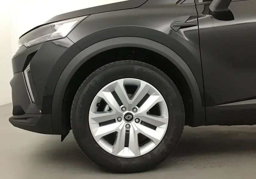 Gros plan sur la roue avant gauche du Renault Captur 2025 noir/gris perle avec jante argentée et détails de carrosserie.