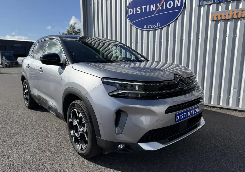 Citroën C5 Aircross 2024 gris Artense avec toit noir, vue 3/4 avant mettant en valeur ses optiques LED et jantes biton.