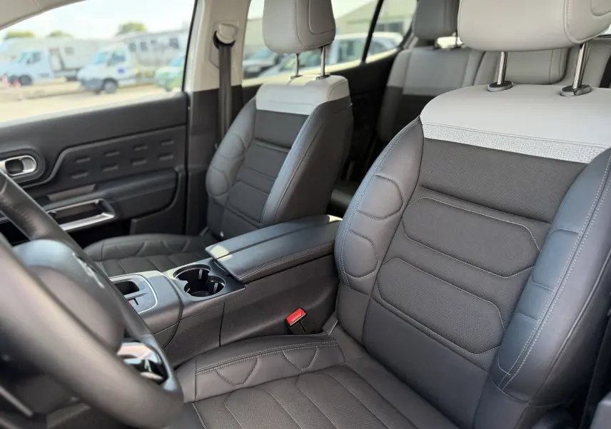 Vue intérieure côté conducteur du Citroën C5 Aircross 2024, sièges bi-ton gris et noir en cuir et tissu.