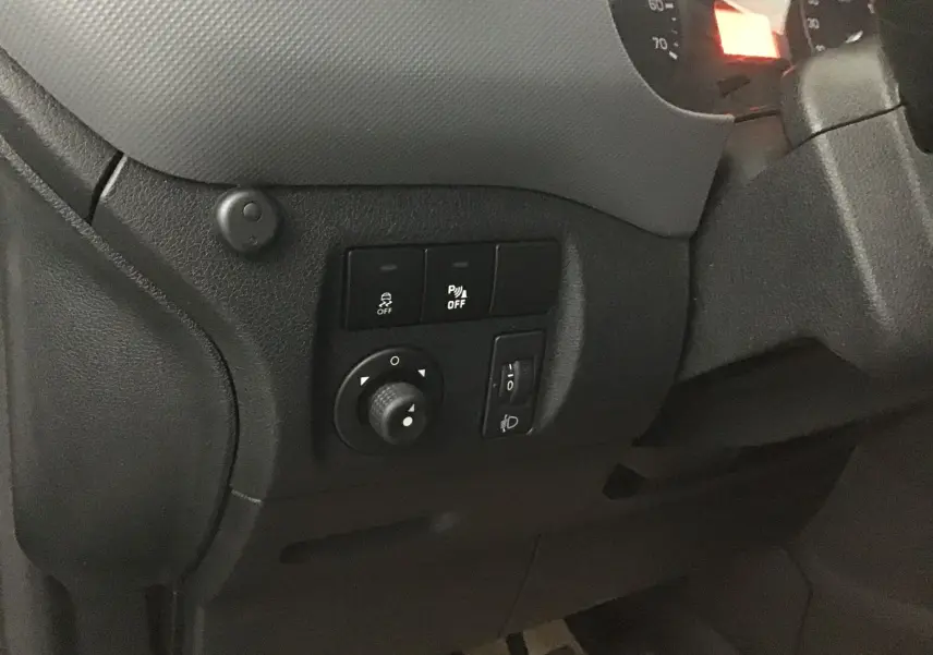 Gros plan sur les commandes noires du tableau de bord côté gauche d'un Citroën Berlingo blanc de 2018.