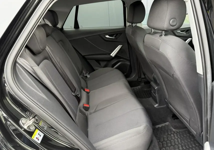 Vue intérieure côté droit sur les sièges arrière gris foncé d'un Audi Q2 noir métallisé 2023 finition S line.