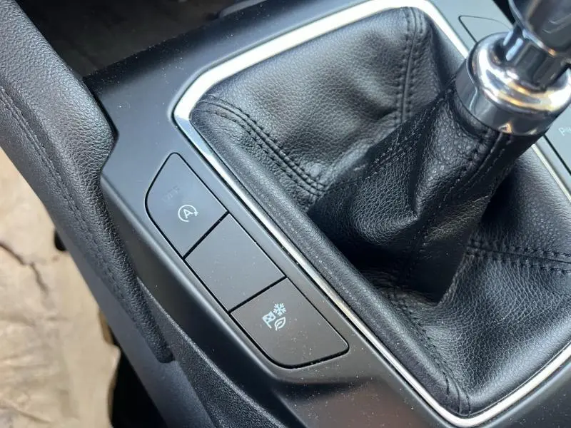 Gros plan sur la console centrale noire du Ford Kuga 2.0 EcoBlue 2021, avec levier de vitesse manuel en cuir.