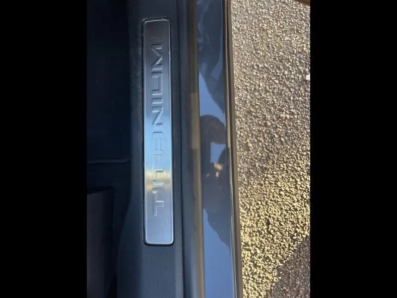 Gros plan sur la plaque de seuil de porte "Titanium" du Ford Kuga gris Magnetic métallisé, vue côté intérieur et extérieur.