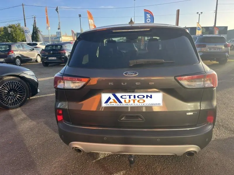 Vue arrière d'un Ford Kuga gris métallisé avec double sortie d'échappement et attelage de remorque visible.