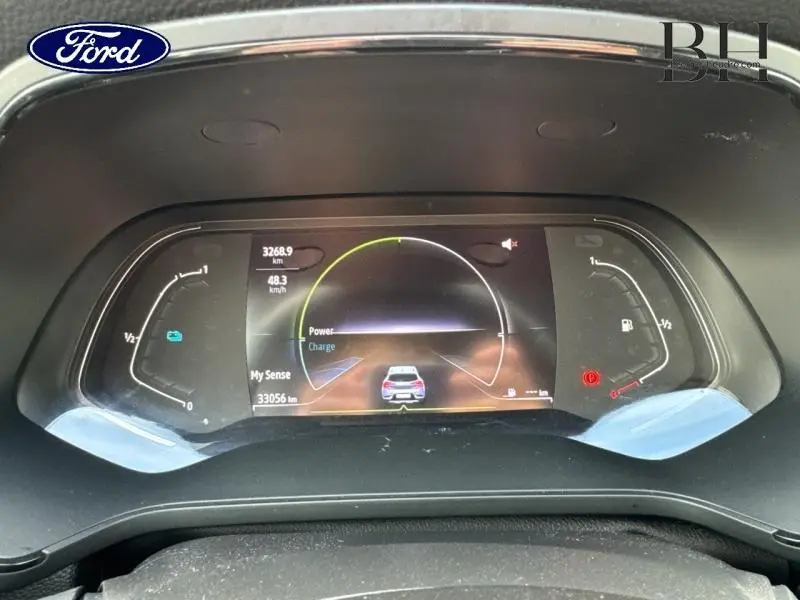 Tableau de bord numérique du Renault Captur gris Highland 2023 montrant l'affichage de conduite hybride.