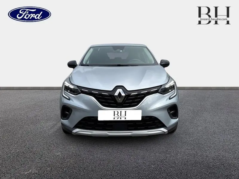 Vue avant d'un Renault Captur 1.6 E-Tech hybride gris Highland avec calandre noire et feux LED distinctifs.