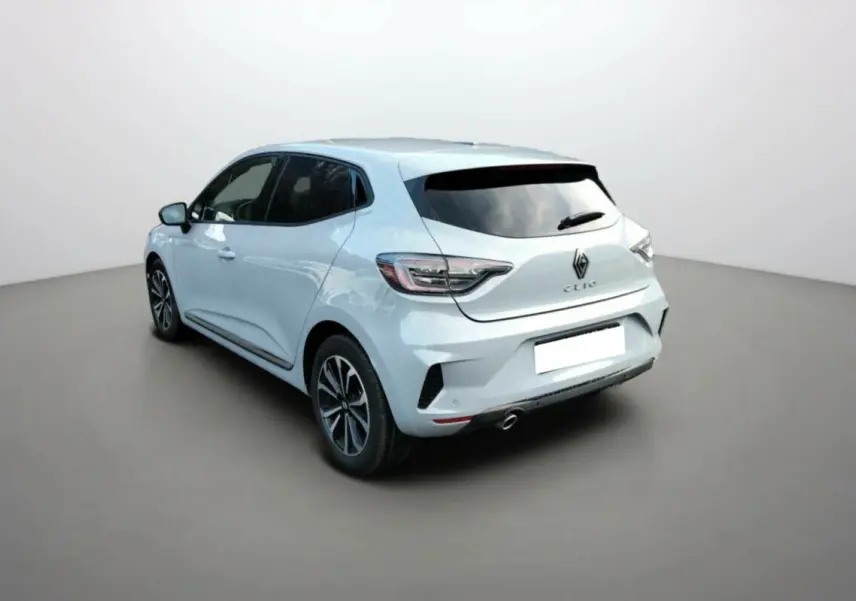 Vue 3/4 arrière droite d'une Renault Clio gris clair avec vitres surteintées et jantes alliage noir.