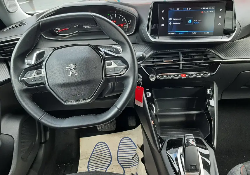 Vue intérieure du poste de conduite du Peugeot 2008 2021, volant compact, écran tactile central et console noire brillante.