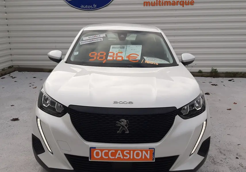 Vue frontale d'un Peugeot 2008 blanc de 2021 avec calandre noire et feux LED en forme de griffes.