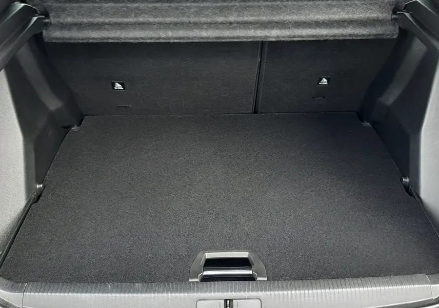 Coffre ouvert vu de l'arrière du Peugeot 2008 blanc, montrant un espace de chargement propre et bien fini.