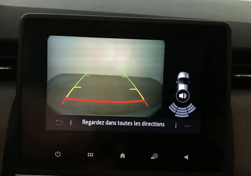 Écran de caméra de recul de la Renault Clio V gris Rafale montrant les lignes de guidage colorées et l'alerte sonore.