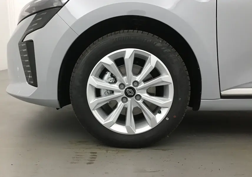 Gros plan sur la roue avant gauche gris rafale d'une Renault Clio V 1.5 DCI 100 Evolution avec jante alliage et logo Renault.