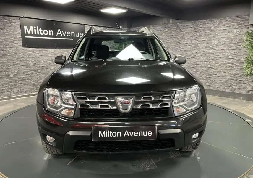 Vue frontale d'un Dacia Duster noir 2016 avec calandre chromée et projecteurs à double optique.