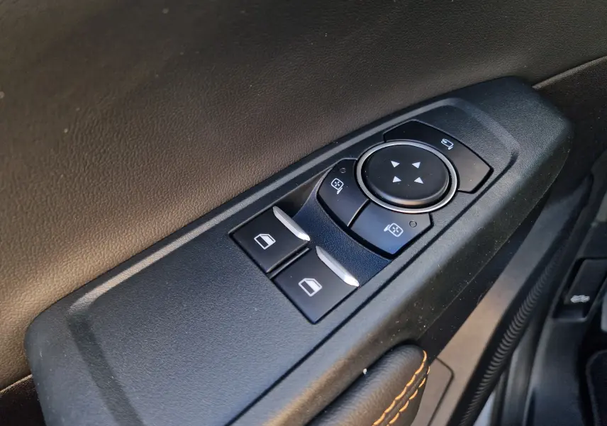 Gros plan sur les commandes de réglage des rétroviseurs et des vitres côté conducteur du Ford Ranger Super Cabine gris Iconic 2026.