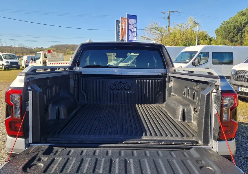 Vue arrière du Ford Ranger Super Cabine gris Iconic avec benne ouverte et revêtement noir marqué Ford.