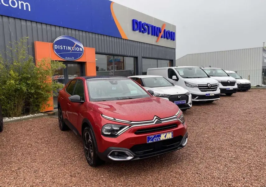 Citroën C4 X rouge Elixir vue 3/4 avant avec toit ouvrant électrique sur parking de concession