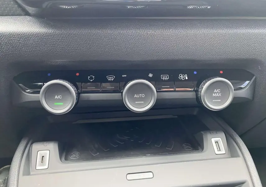 Gros plan sur les commandes de climatisation automatique et recharge sans fil du Citroën C4 X Rouge Elixir 2022.