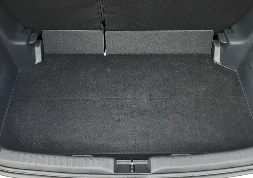 Coffre ouvert vu de face d'une Toyota Yaris blanche 2023, montrant un espace de rangement propre et noir.