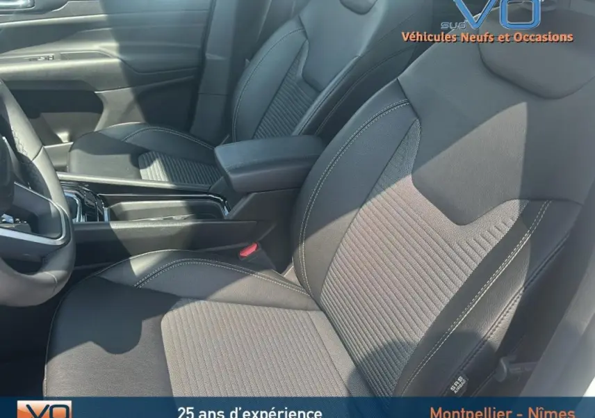 Vue intérieure rapprochée des sièges avant noirs du Jeep Compass 2024 avec coutures contrastées et accoudoir central.