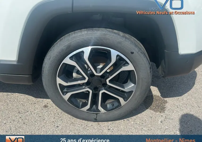 Gros plan sur la jante 17 pouces noire et argent du côté gauche d’un Jeep Compass blanc 2024.