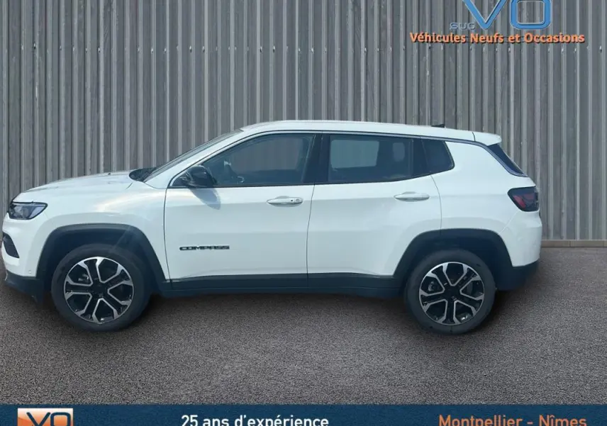 Vue de profil côté gauche d'un Jeep Compass blanc 2024 avec jantes 17 pouces et roue de secours visible à l'arrière.
