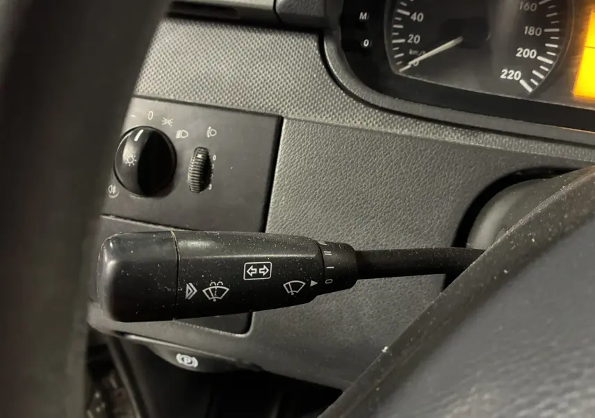 Gros plan sur la manette de commandes d’essuie-glace du tableau de bord noir du Mercedes Vito gris 2012.