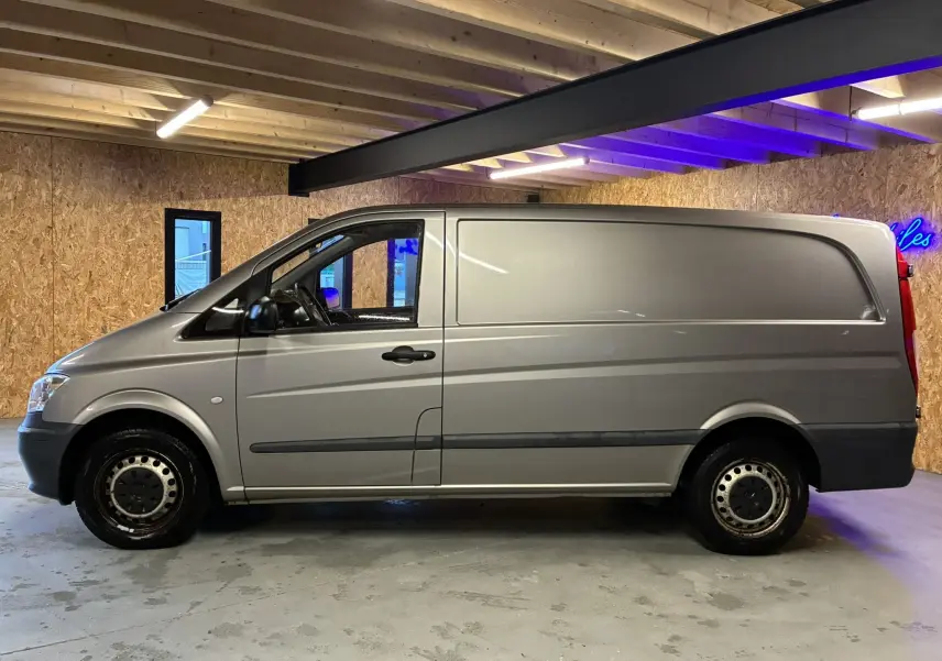 Vue de profil côté gauche d’un Mercedes Vito 2.8 113 CDI fourgon long gris, avec jantes acier et poignées noires.