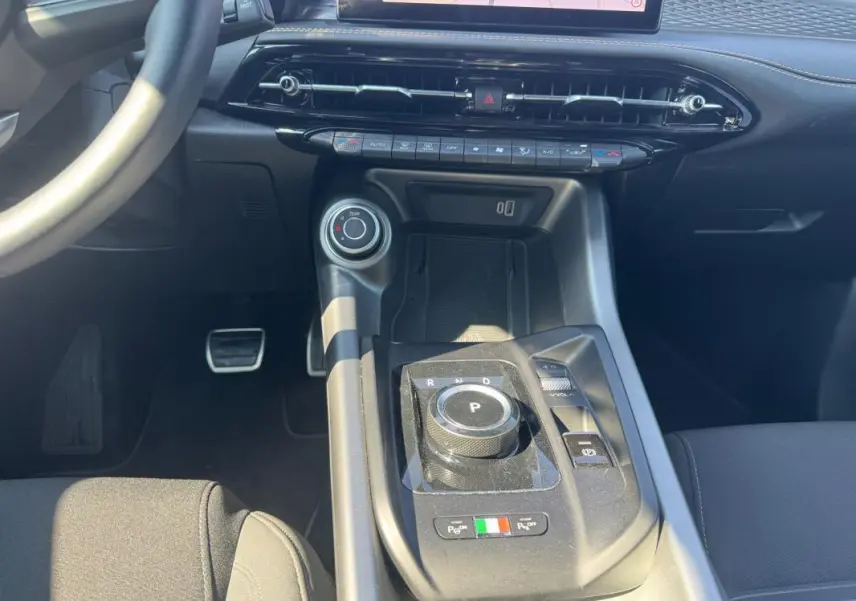 Gros plan sur la console centrale noire de l'Alfa Romeo Tonale 2025 avec molette de boîte auto et détails italiens.