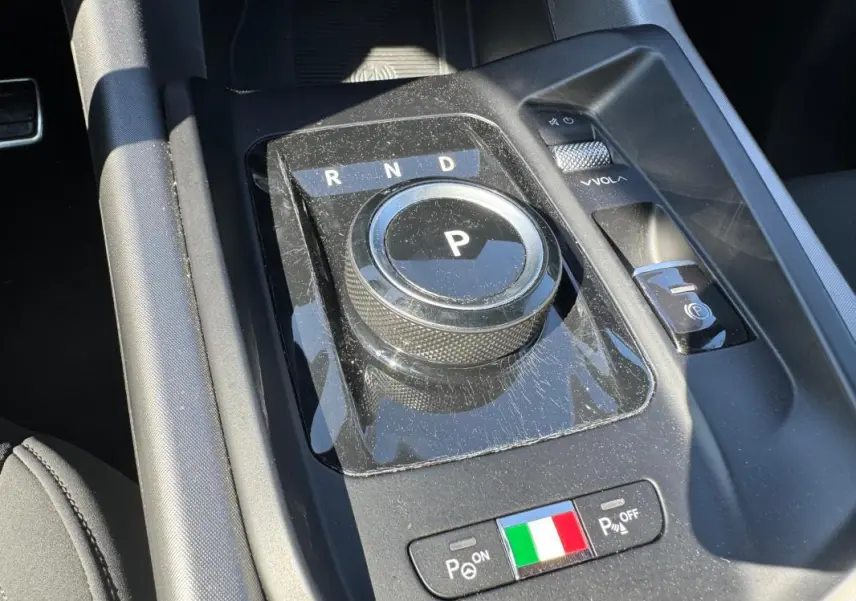 Gros plan sur la molette de boîte automatique et les commandes de la console centrale de l'Alfa Romeo Tonale 2025.