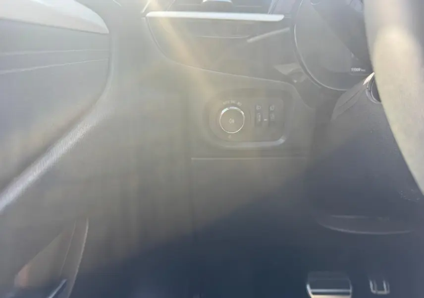Détail intérieur côté gauche de l’Opel Corsa 2025 noir, avec commandes d’éclairage et pédales visibles.