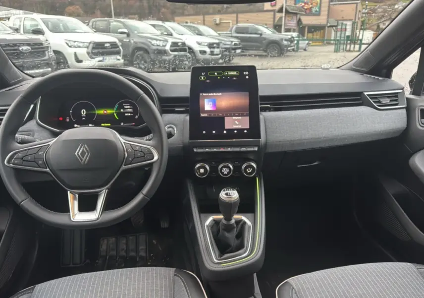 Vue intérieure avant de la Renault Clio V TCe 90 Techno Plus 2025, tableau de bord moderne avec écran tactile vertical et boîte manuelle.