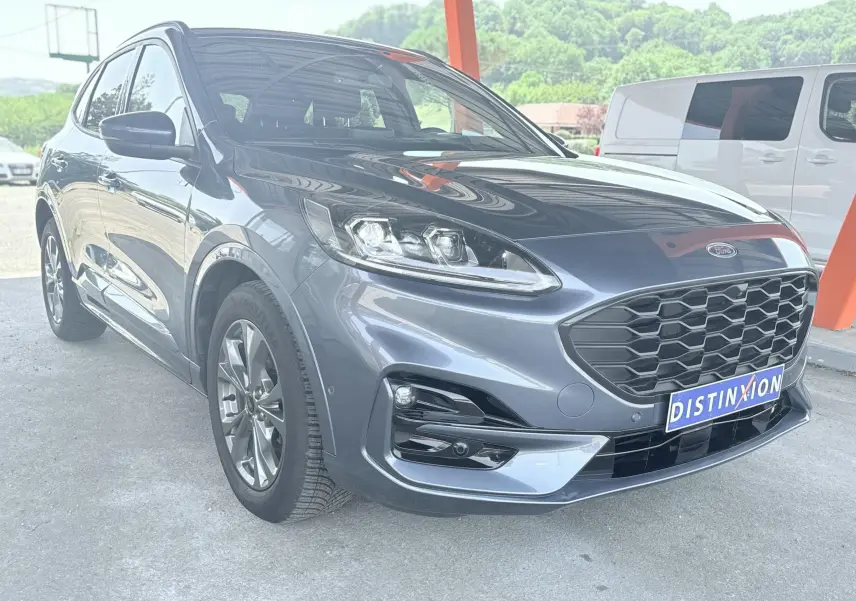 Vue 3/4 avant gauche d'un Ford Kuga 2.0 EcoBlue 120 BVA ST-Line X bleu azur avec calandre noire et jantes alliage.
