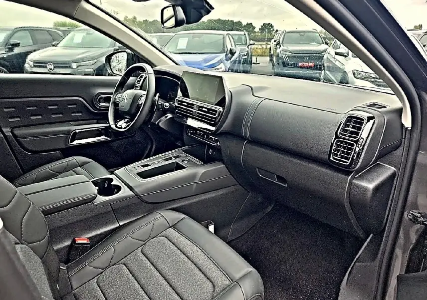 Intérieur avant du Citroën C5 Aircross gris 2025, vue côté passager avec tableau de bord moderne et écran tactile.