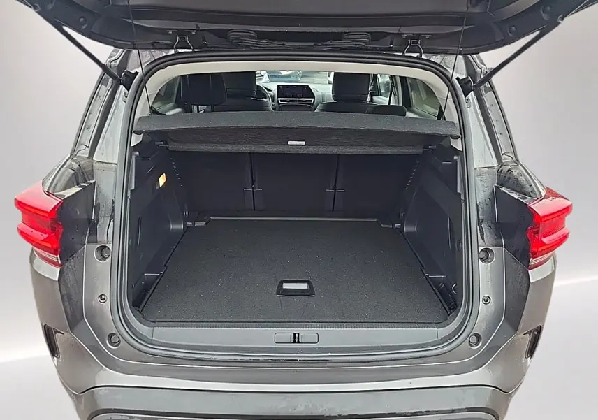 Coffre ouvert vu de l'arrière d'un Citroën C5 Aircross gris 2025, montrant l'espace de chargement et la tablette cache-bagages.