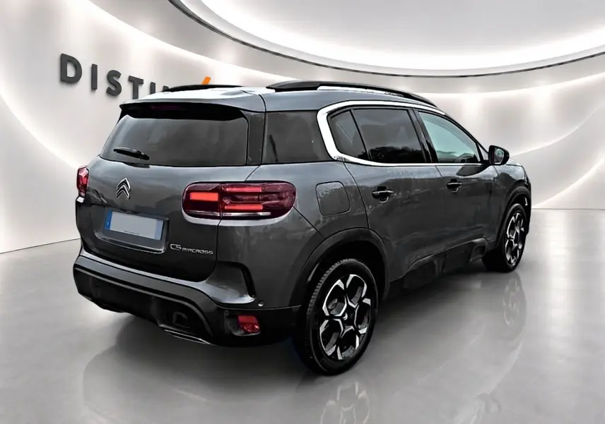 Vue 3/4 arrière droite du Citroën C5 Aircross gris 2025 avec vitres teintées et jantes alu distinctives.