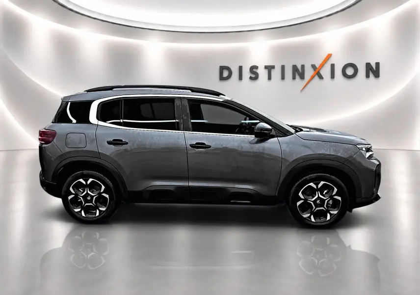 Profil droit du Citroën C5 Aircross gris 2025 avec jantes alu et barres de toit en studio lumineux.