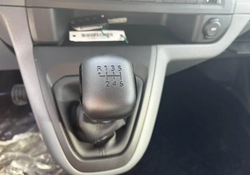 Gros plan sur le levier de vitesses manuel noir du Peugeot Expert Fourgon gris platinium, intérieur avant.